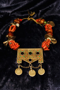 Collana berbera in corallo, ambra e argento con monete e conchiglie e pendente decorato a smalti verdi e gialli. Marocco.